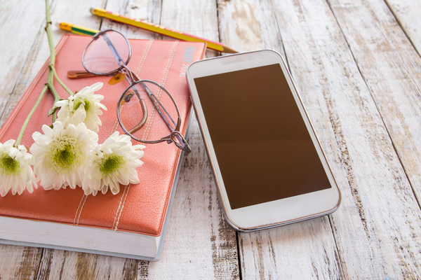 Téléphone et carnet papier côte à côte pour s'organiser
