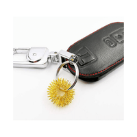 Bague hérissée dorée utilisée comme porte-clés, fixée à un étui de clés