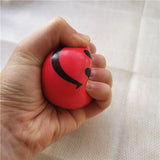 Balle anti-stress Smiley rouge serrée dans la main, montrant la flexibilité du matériau