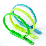 Trois bracelets à tirette en bleu, vert clair et vert foncé, conçus pour stimuler et réduire le stress