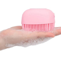 Brosse de douche doseuse rose en main, produisant de la mousse pour un lavage efficace
