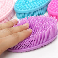 Main appuyant sur les picots de la brosse sensorielle violette, montrant la souplesse du silicone