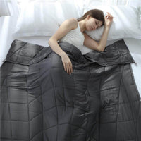 Femme dormant paisiblement sous une couverture lestée gris foncé, idéale pour réduire le stress et favoriser le sommeil