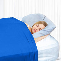 Femme dormant paisiblement sous un drap de compression bleu, favorisant relaxation et sommeil réparateur
