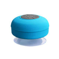 Enceinte portable waterproof bleue avec commandes sur le dessus et ventouse au-dessous