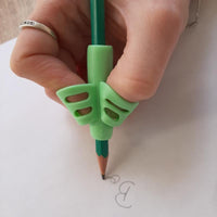 Guide doigt vert en utilisation pour écrire, favorisant une meilleure position des doigts sur le crayon