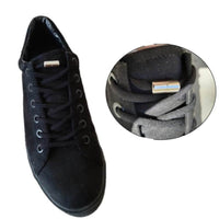 Chaussure noire équipée de lacets élastiques terminés par un embout métallique vissé, pour un serrage rapide et pratique