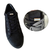 Chaussure noire équipée de lacets élastiques terminés par un embout métallique vissé, pour un serrage rapide et pratique