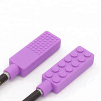 Zoom sur l'embout à mâchouiller brique violet, montrant différentes textures