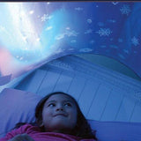 Une enfant allongée sous un paravent de lit polaire avec des flocons de neige et des aurores boréales
