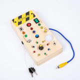 Planche d'activité Montessori smart en bois, vue en angle, avec câbles, interrupteurs et voyants lumineux