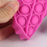 Gros plan sur le Press-in bubble rose, montrant sa flexibilité et les bulles en silicone
