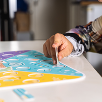 Enfant manipulant une pièce du jeu Super Co-Quotidien, développement de la motricité fine